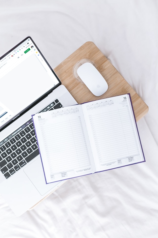 Ordinateur portable et agenda ouvert sur un bureau
